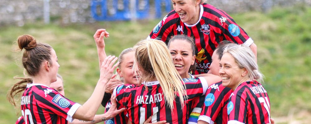 Lewes FC team celebrates together on pitch